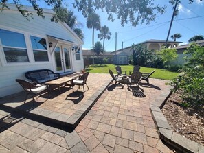A patio area with outdoor furniture, a covered seating area, and a well-maintained lawn.