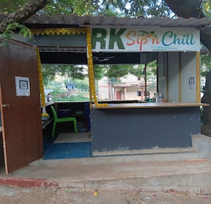 Um pequeno quiosque ao ar livre chamado 'RK Sip n Chill', com balcão e área de estar.