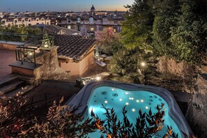 A rooftop pool with a view of a cityscape, including a prominent dome building.