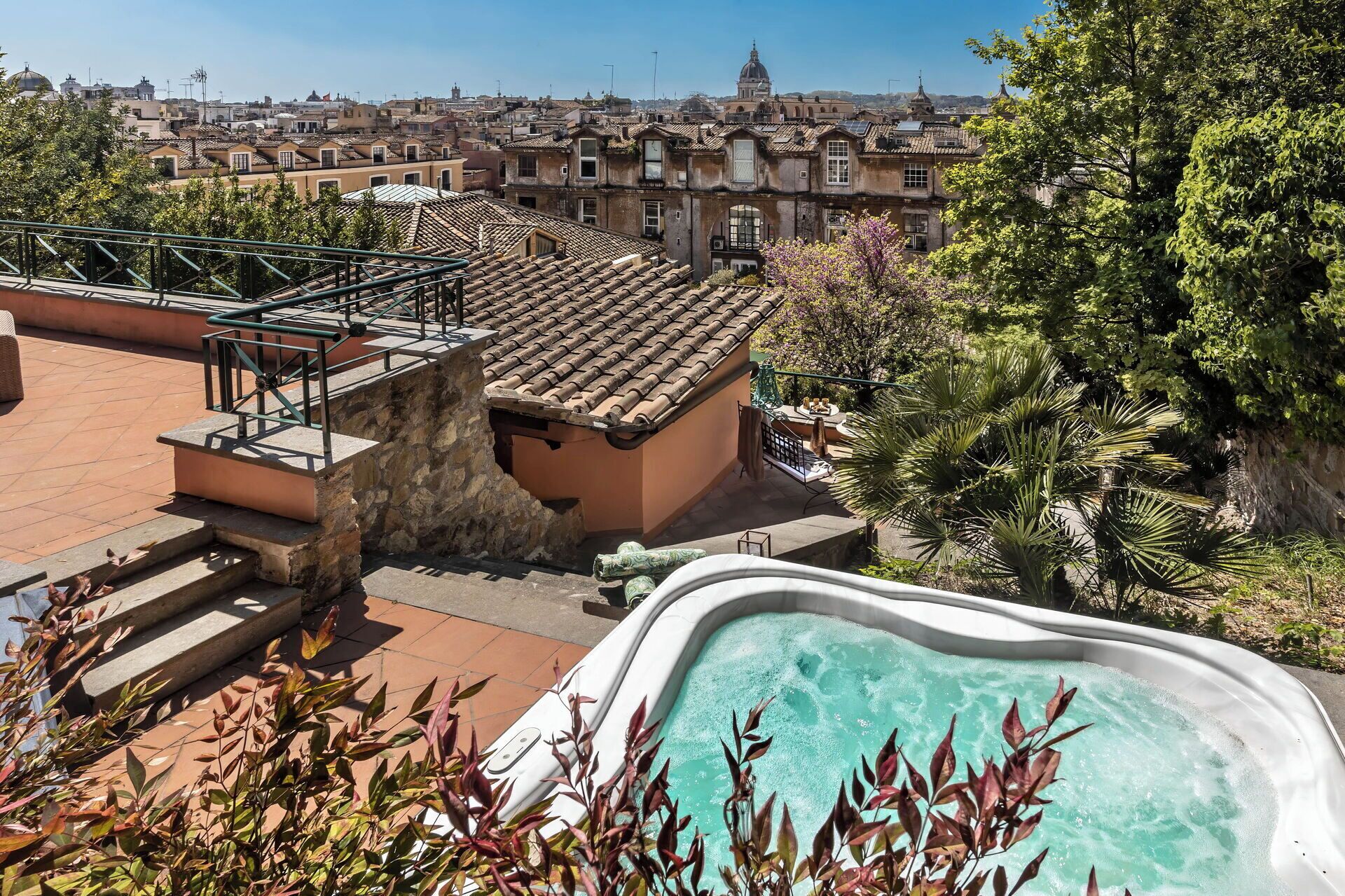 Una piscina en la azotea con vistas a un paisaje urbano, incluyendo un edificio de forma abovedada a lo lejos.