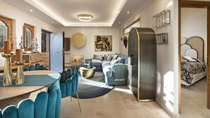 Un salon moderne comprenant un coin repas, un grand canapé, une table basse et un lit avec une tête de lit.