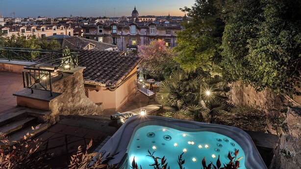 Une piscine sur le toit offrant une vue sur le paysage urbain, notamment sur un imposant bâtiment à coupole.