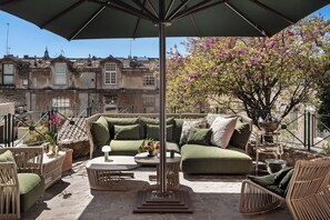 An outdoor seating area with a sofa, chairs, and a table, overlooking a building with traditional architecture. - Villa in Rome with 3 bedrooms sleeps 8 (Rome)