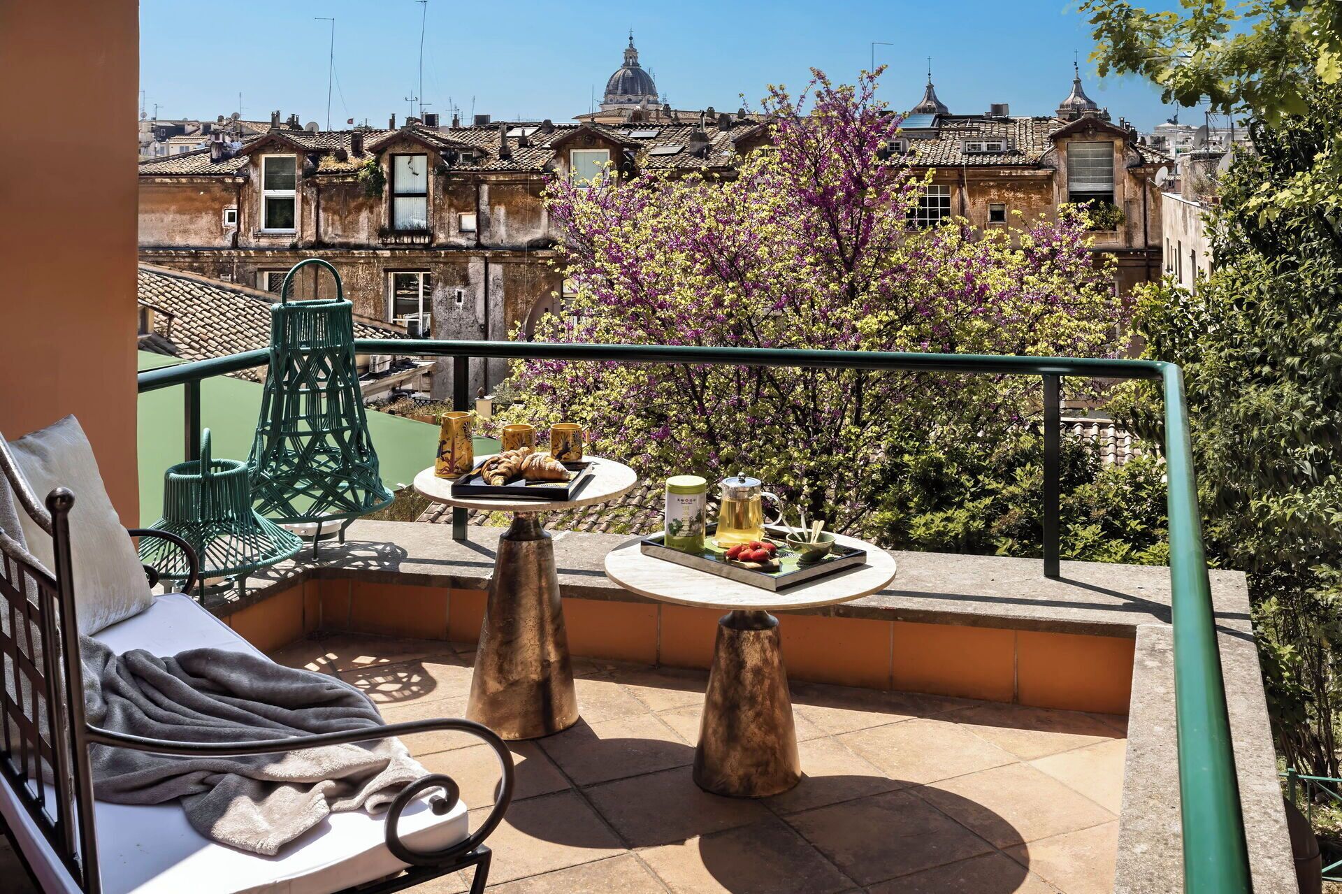 Un balcón con una mesa para dos, una silla y vistas de la ciudad.