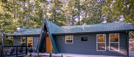 A house with a sloped roof, a front porch, and a mailbox.