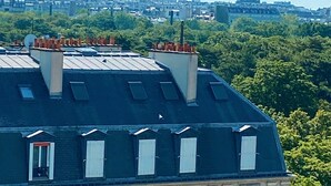 Een gebouw met een donker dak, meerdere ramen en een balkon.