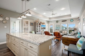 A spacious kitchen with a large island, built-in cabinetry, and pendant lighting.