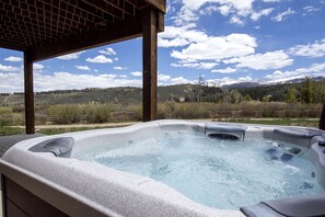 Un bain à remous avec vue sur les montagnes et un ciel dégagé.