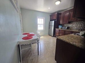 A kitchen with a dining table, a refrigerator, and a window. - Amazing large 3 BD apartment in NJ Close 15 minutes to Metlife (Kearny)