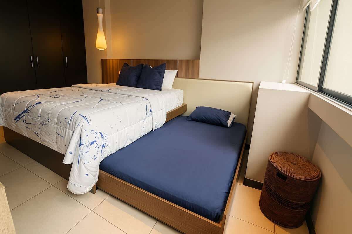Une chambre à coucher avec un lit, une table de chevet et une fenêtre.