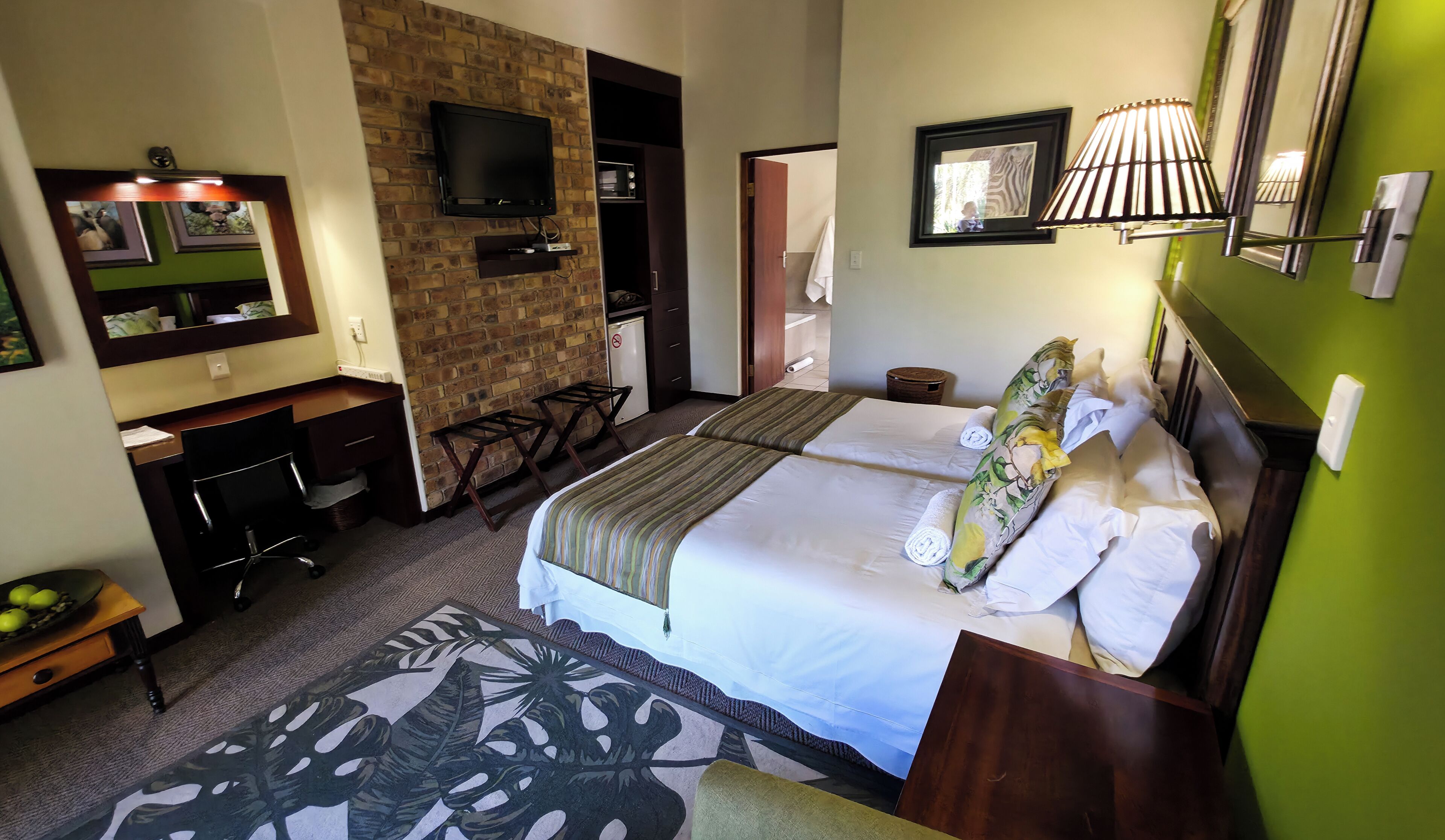 Une chambre d’hôtel avec un lit, un bureau, une télévision et une salle de bain.
