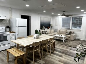 Una cocina moderna con comedor, sofá y ventilador de techo.