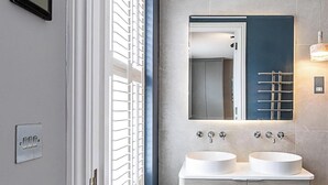 A bathroom with two sinks, a mirror, and a window with blinds. - Elegant Marylebone/baker St Escape (London)