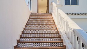 Una escalera con baldosas estampadas que conduce a una puerta.