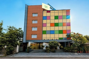 Ein mehrstöckiges Hotel mit einer modernen Fassade, einer gut sichtbaren Schilder und einer Treppe, die zum Eingang führt.