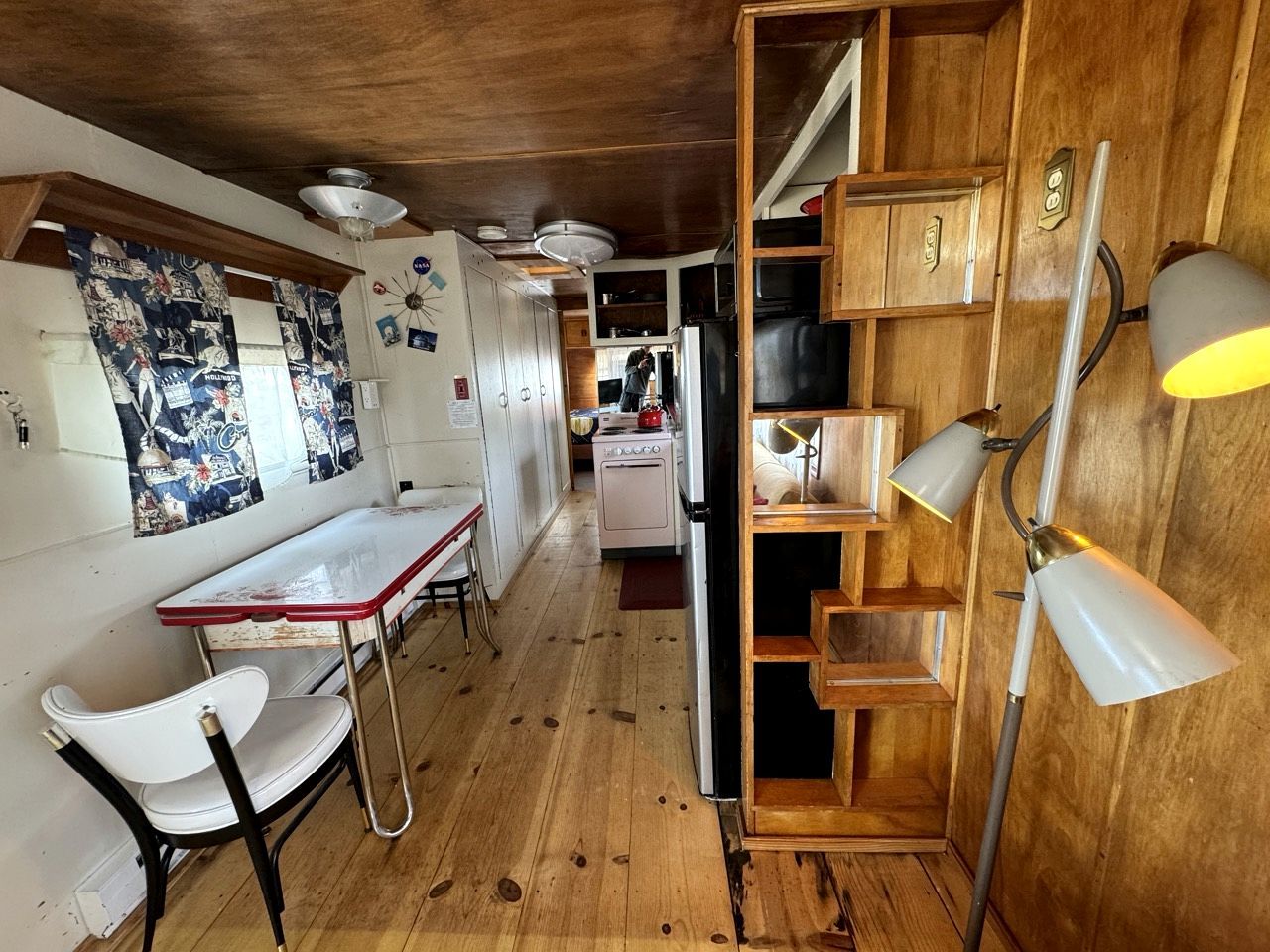 Una cocina con armarios de madera, una estufa y un comedor con mesa y sillas.