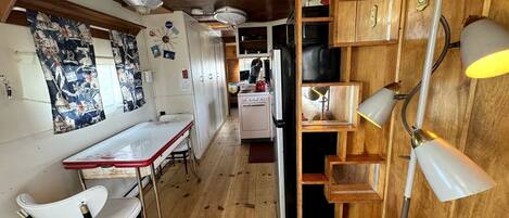 Una cocina con armarios de madera, una estufa y un comedor con mesa y sillas.