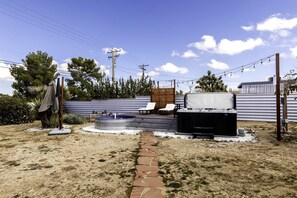 A backyard with a hot tub, lounge chairs, a wooden deck, and a brick pathway. - Stunning Cottage with Hot-tub and Fireplace in Yucca Valley, California (Yucca Valley)