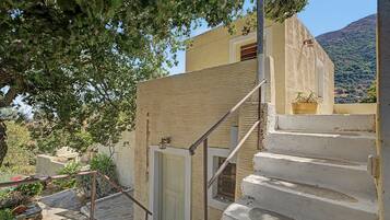 Una escalera que conduce a un edificio con un muro texturizado y una puerta.