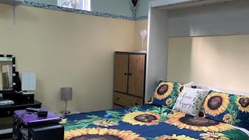Een slaapkamer met een bed, een bureau met een computer, een kledingkast en een dakraam.