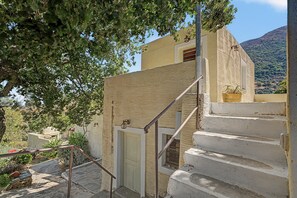 Escada que leva a um edifício com parede texturizada e uma porta.