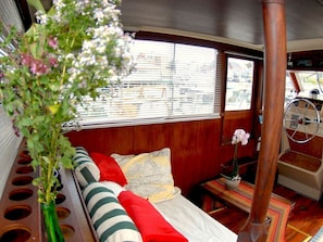 Ein gemütliches Zimmer mit Bett, kleinem Tisch und Fenster mit Jalousien.