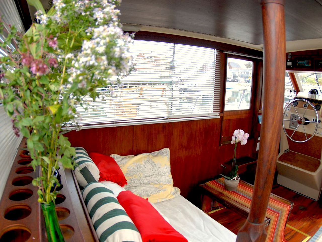 A cozy interior with a bed, a small table, and a window with blinds.