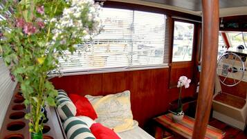 A cozy interior with a bed, a small table, and a window with blinds.