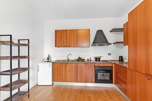 Una cocina moderna con armarios de madera, horno empotrado y lavavajillas.