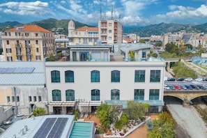 A multi-story building with a rooftop garden, a swimming pool, and a parking area. - Mediterranea Apartments (Savona)