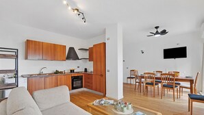 A modern apartment with a kitchen, dining area, and living room. - Mediterranea Apartments (Savona)