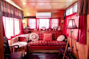 Ein gemütliches Interieur mit einem roten Sofa, einem kleinen Tisch und einer Lampe.