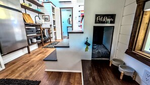 A pet-friendly room with a pet bed, a pet room sign, and a pet feeding station.