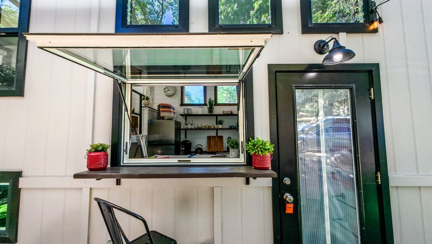 A kitchen area with a window, a door, and a small outdoor seating area.