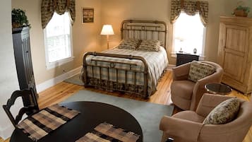Ein Schlafzimmer mit einem Bett, einem Sessel, einem Tisch und einem Schrank.