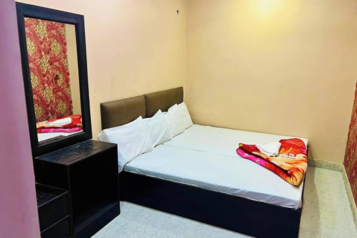 Ein Schlafzimmer mit einem Bett, einem Nachttisch, einem Spiegel und einer Wand mit einem Muster.