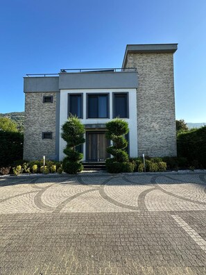 A modern two-story house with a brick facade, a large front door, and a driveway leading to the entrance. - Aşk Villa Bungalov Sapanca (Sapanca)