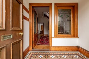 A wooden door labeled 'LETTERS,' a patterned rug, and a wooden floor with a geometric design. - Woodburn Terrace (No 8) | St Andrews (St Andrews)