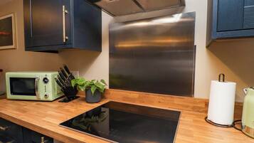 A modern kitchen with a built-in microwave, a stove, and a sink.