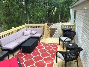 Eine Terrasse mit einer Couch, einem Couchtisch und Stühlen.