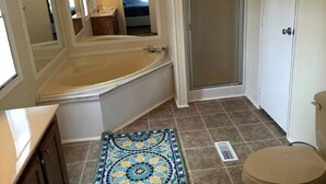A bathroom with a bathtub, a shower, a toilet, and a mirror. - Spacious Modular Rental on Huge Horse and Cattle Farm near Charlottesville, Virginia (Gordonsville)