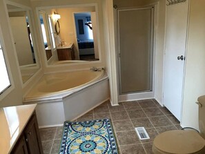 A bathroom with a bathtub, a shower, a toilet, and a mirror. - Spacious Modular Rental on Huge Horse and Cattle Farm near Charlottesville, Virginia (Gordonsville)