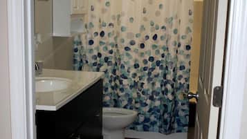 A bathroom with a toilet, a sink, and a shower curtain.