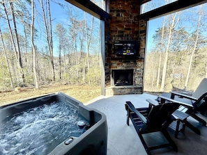 A hot tub, outdoor seating, a fireplace, and a view of the forest. - Romantic Cabin in Shady Grove Area of the Smoky Mountains: A Perfect One-Level Retreat for Couples (Sevierville)