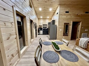 A wooden interior with a dining area, kitchen, and living space. - Romantic Cabin in Shady Grove Area of the Smoky Mountains: A Perfect One-Level Retreat for Couples (Sevierville)