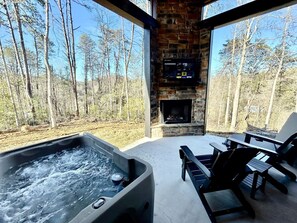 A hot tub, outdoor seating, a fireplace, and a view of the forest. - Romantic Cabin in Shady Grove Area of the Smoky Mountains: A Perfect One-Level Retreat for Couples (Sevierville)