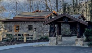 A rustic stone building with a wooden roof, a wooden door, and a signboard. - Romantic Cabin in Shady Grove Area of the Smoky Mountains: A Perfect One-Level Retreat for Couples (Sevierville)