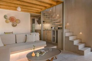 Un intérieur moderne avec un canapé, une table ronde et un escalier.