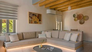 Una sala de estar moderna con un sofá seccional, una mesa de centro, un cuadro y decoración de pared.
