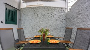 Ein Esstisch mit Stühlen, einer Blumenvase und Gläsern.